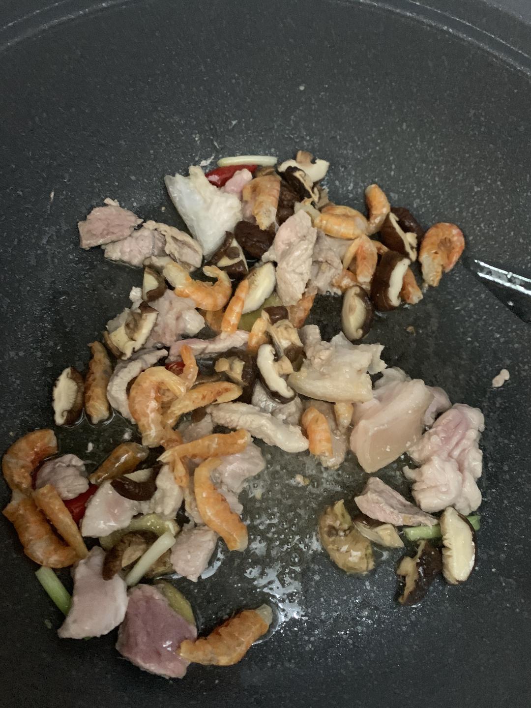 Stir-frying pork with ginger, dried shrimp and mushrooms