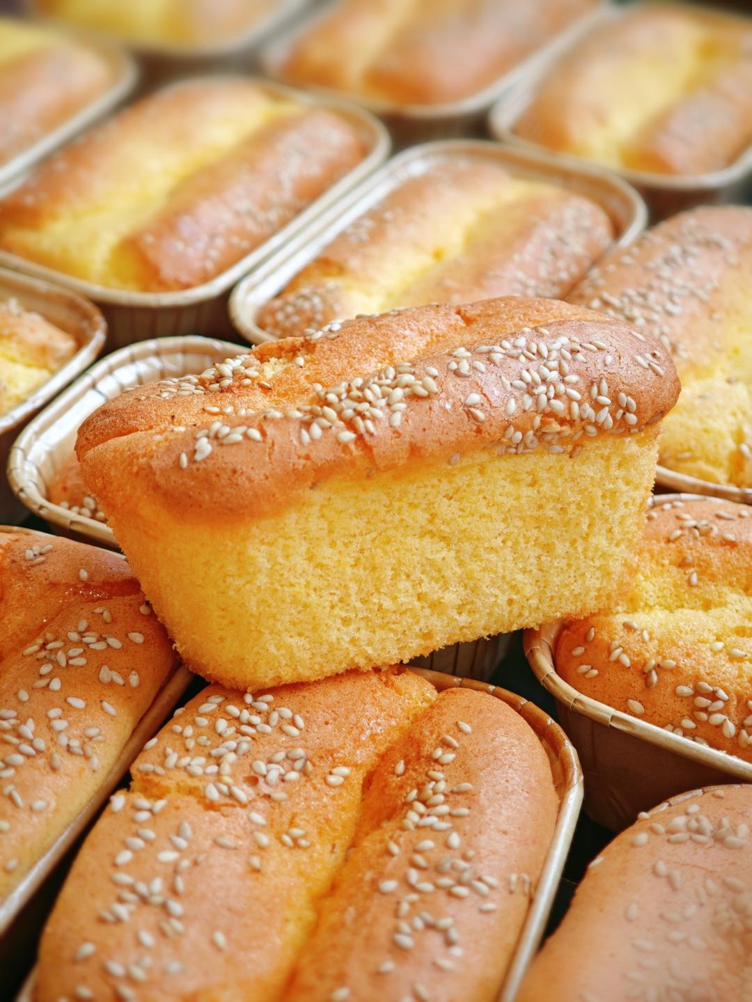 Bite through the crisp, sugary crust into the soft, stretchy center - the signature texture of this cake.