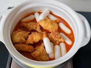 Toss the rice cakes and half the chicken in the sauce