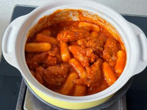 Toss the chicken and rice cakes until fully coated in the glossy sauce