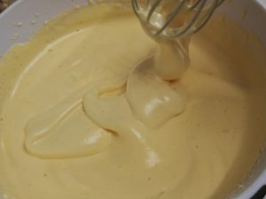 Whip until the batter falls in thick ribbons and a lifted figure-8 holds its shape - the whole-egg ribbon stage.