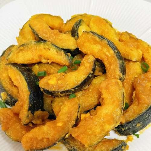 Golden crispy salted egg yolk pumpkin pieces in a serving dish