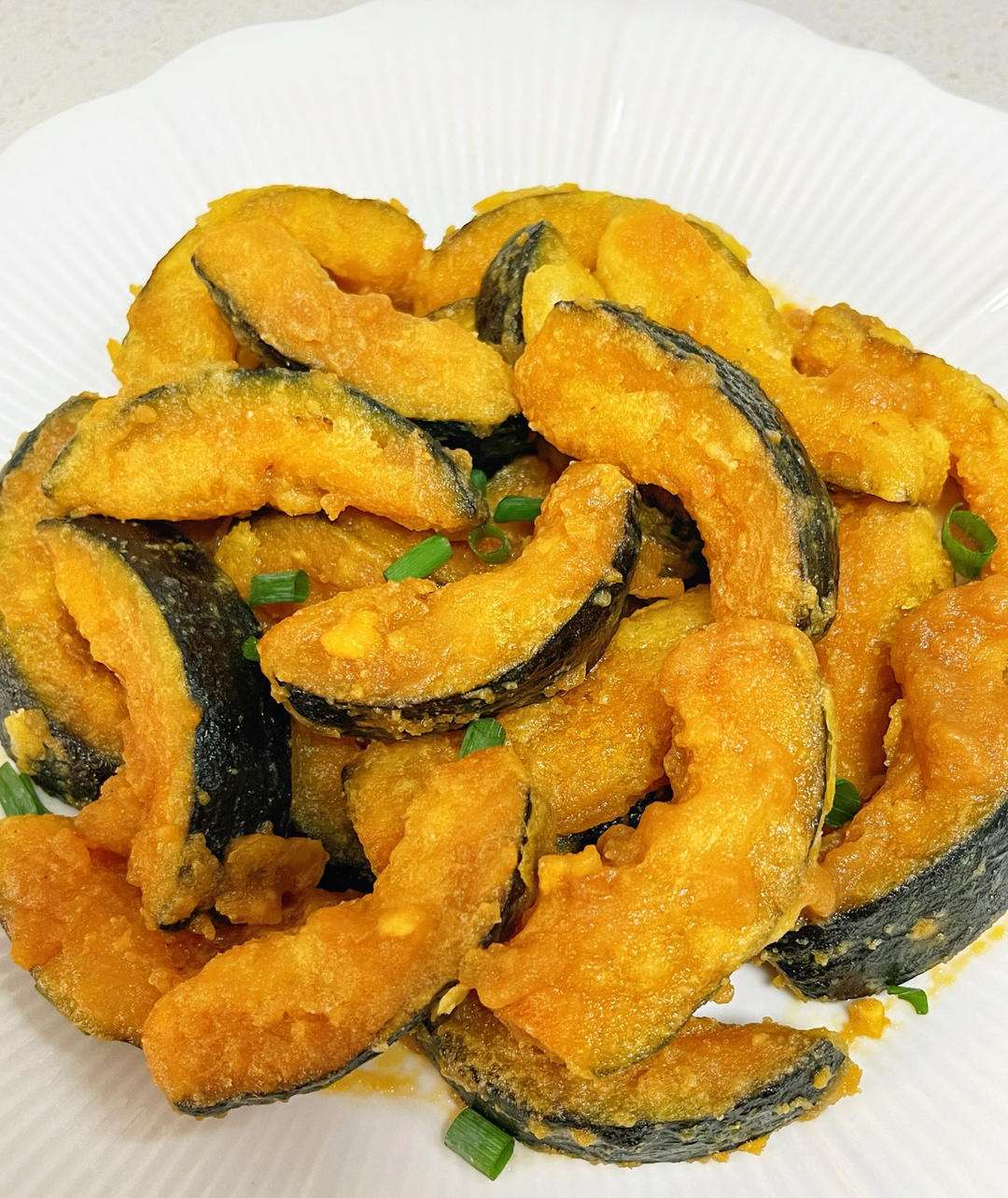 Golden crispy salted egg yolk pumpkin pieces in a serving dish