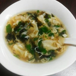 When the egg ribbons float to the surface, turn off the heat and season with white pepper, salt and sesame oil, then sprinkle with scallions, cilantro and dried shrimp.
