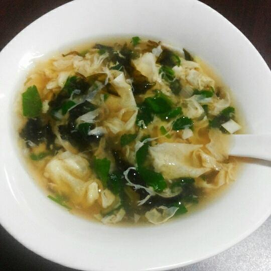 When the egg ribbons float to the surface, turn off the heat and season with white pepper, salt and sesame oil, then sprinkle with scallions, cilantro and dried shrimp.