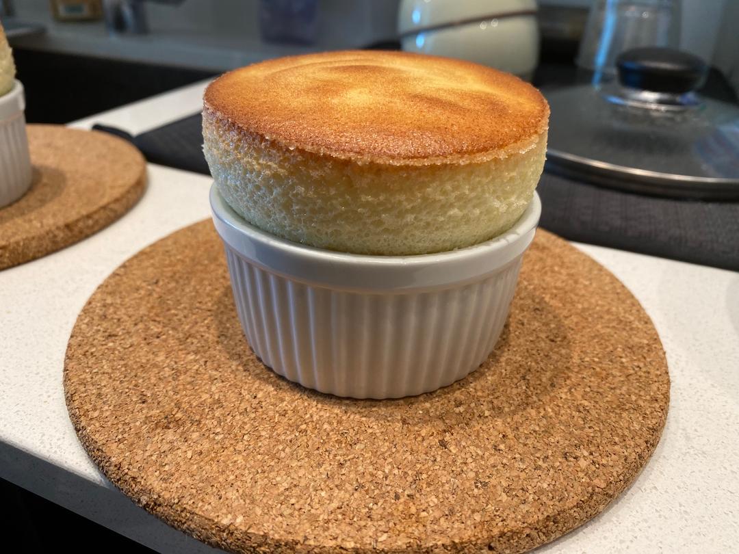 Tall baked souffle in a buttered cup