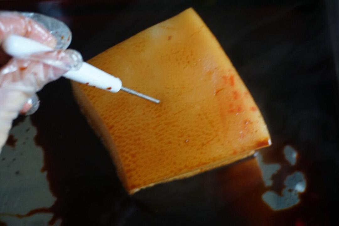 Soak the pricked pork belly skin side down in dark soy for 10 minutes so the color penetrates.