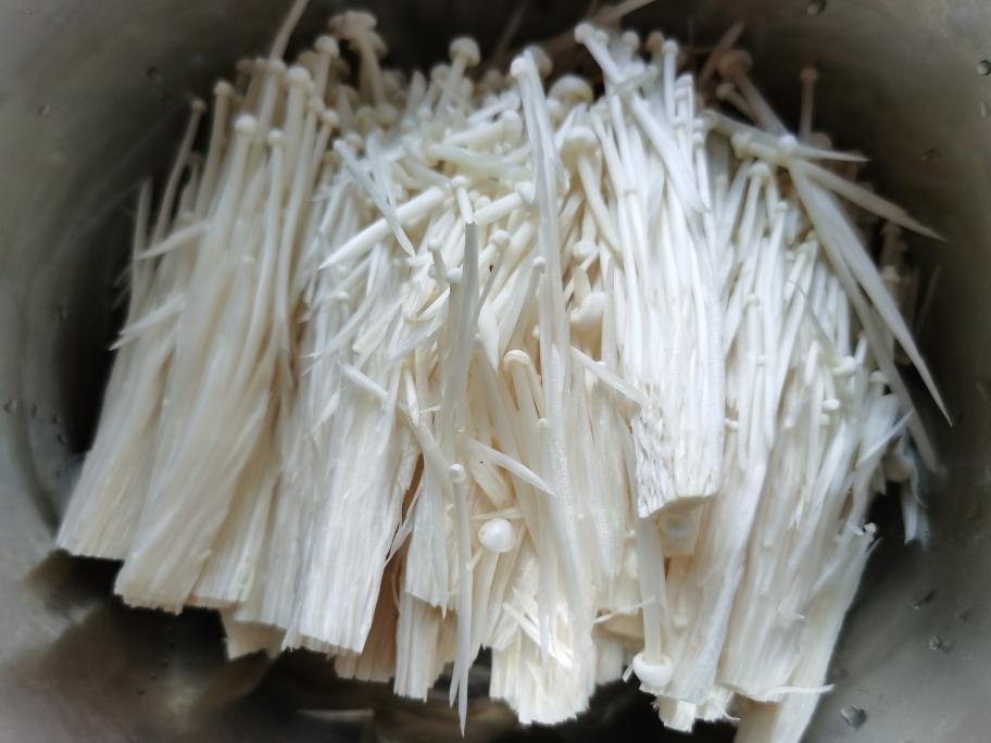 Trim the enoki mushrooms and separate the strands