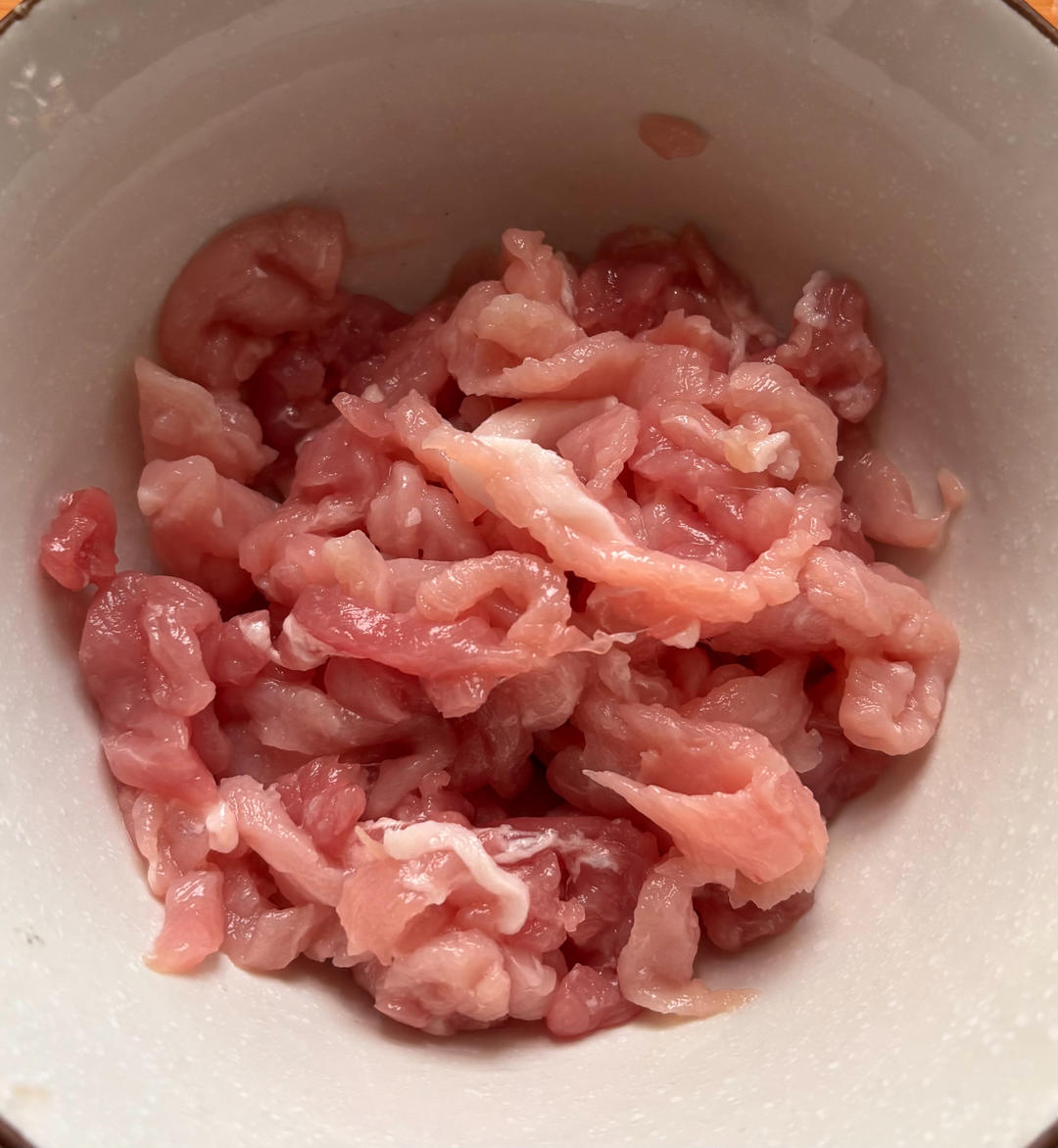 Cut the pork into shreds and marinate briefly with wine