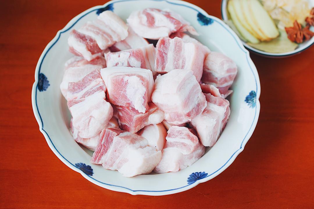Soaking and washing pork belly cubes in cold water