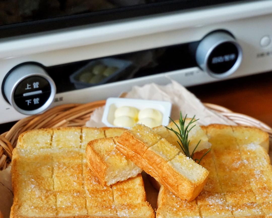 Brushing butter and sprinkling sugar on bread