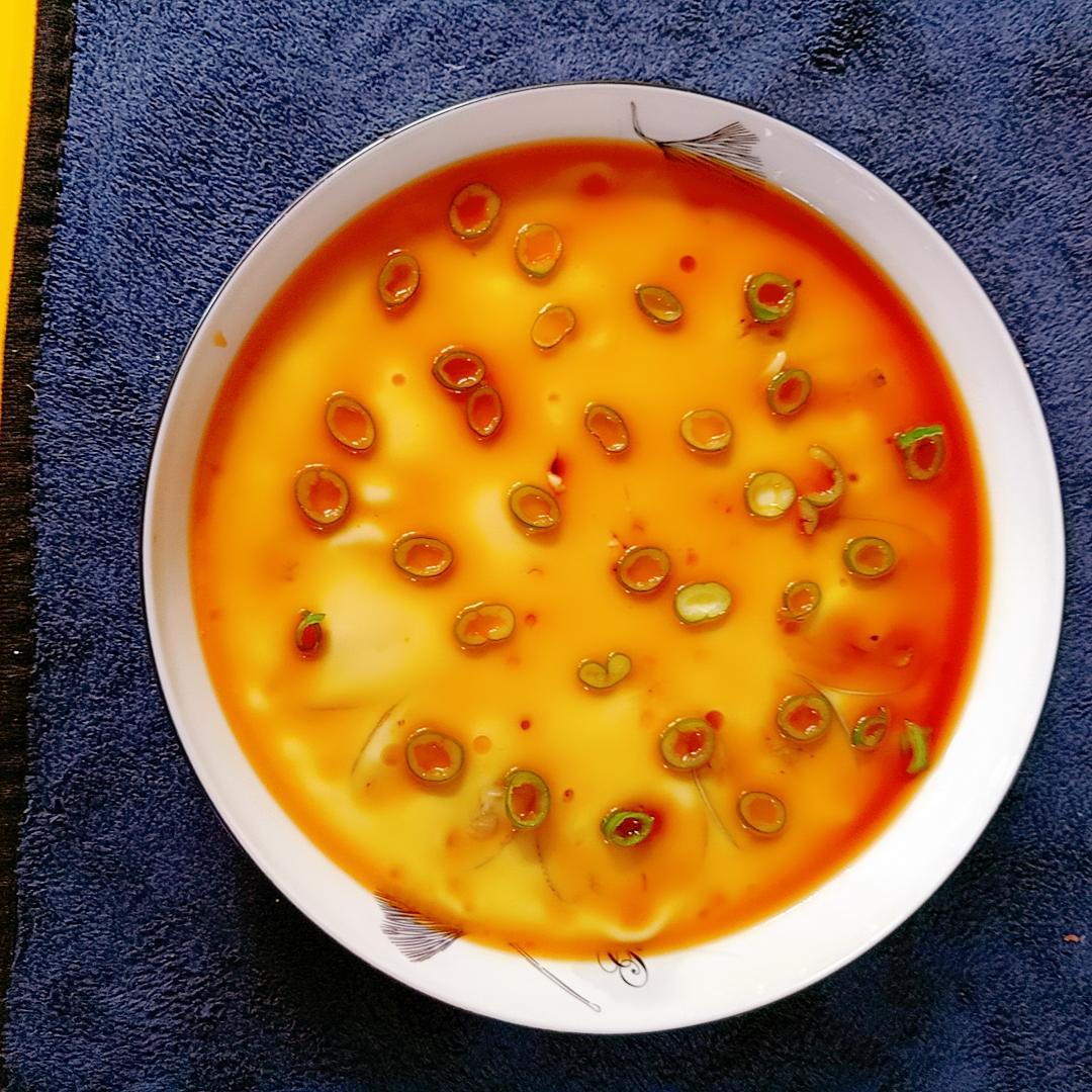 Silky steamed egg with clams garnished with scallions