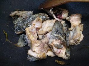 Fry the fish bones golden, add the greens, and pour in the boiling water
