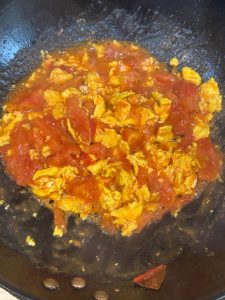 Return the scrambled eggs to the wok and toss with the tomato sauce over low heat for 30 seconds.
