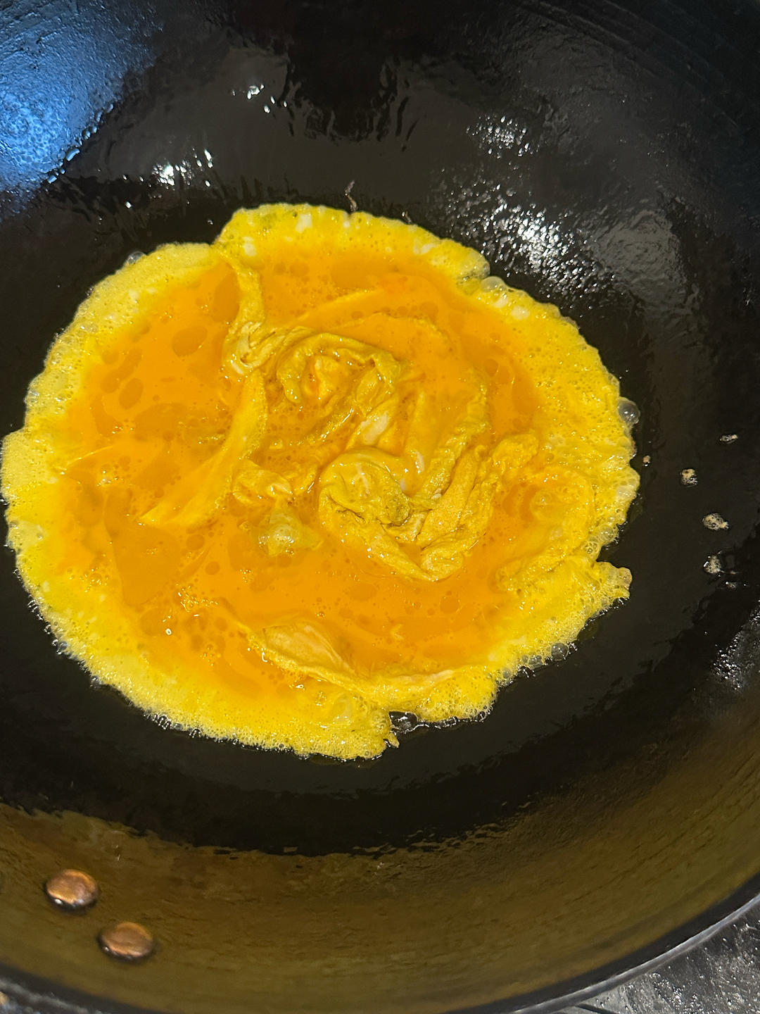 Beat the eggs with salt and a spoonful of warm water, then scramble them in hot oil until golden and fluffy.