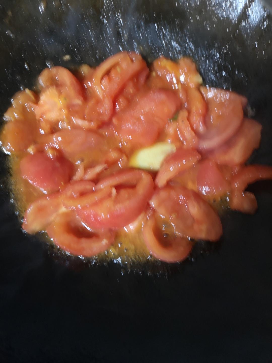 Heat the neutral oil in the pot over medium heat. Add the ginger slices and the scallion whites and cook until fragrant, about 30 seconds. Add the chopped tomatoes and stir-fry for about 1 minute, pressing them gently with a spatula, until they soften and release their juice.