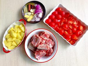 Prep the ribs, potatoes, tomatoes, and aromatics