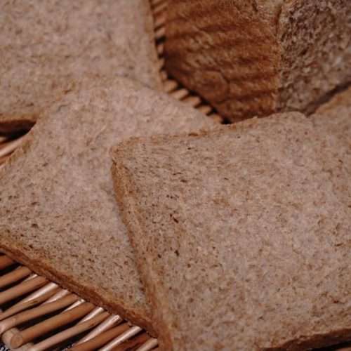 A baked sugar-free whole wheat toast loaf with a craggy golden crust