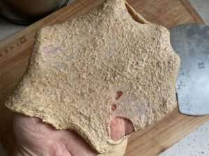 Stretch a small piece of dough into a thin membrane to test the gluten development