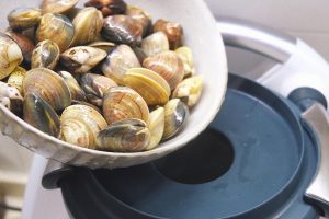 Add the clams and wine and cook until the clams open