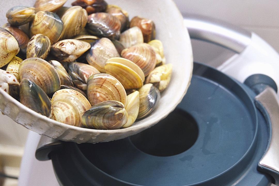 Add the rinsed, sand-spit clams and the huang