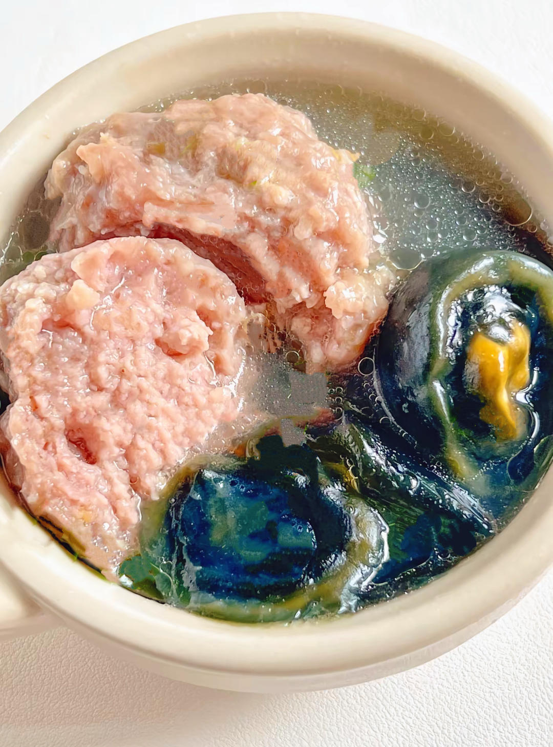 Yam and century egg meatball soup in a double boiler cup with clear broth
