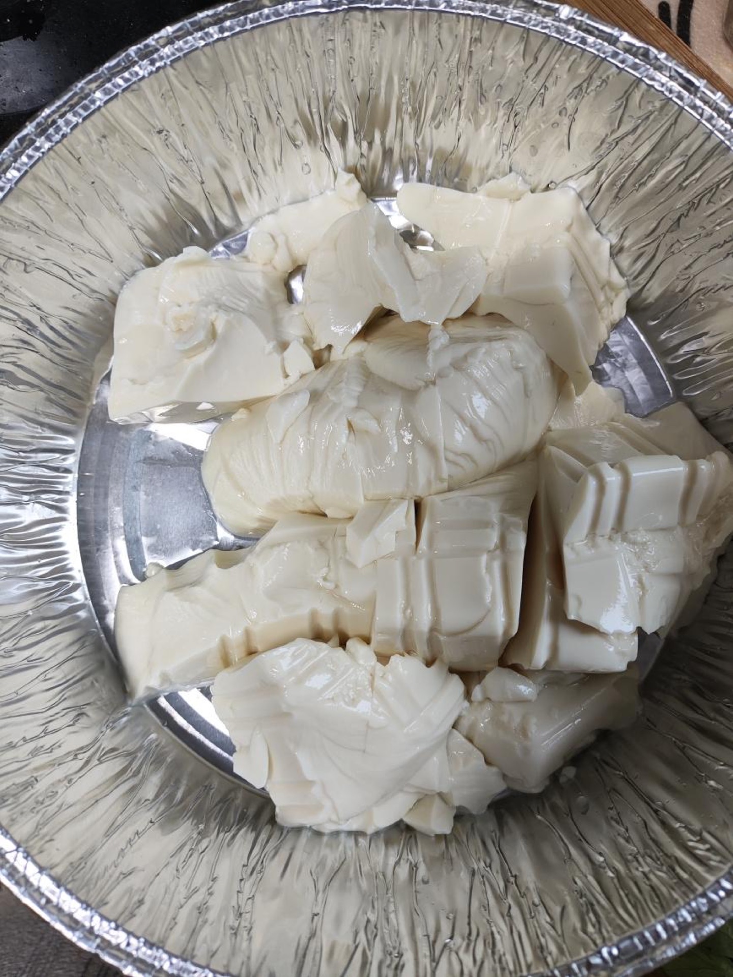 Turn the silken tofu out into a foil container and score the surface 3-4 times with a knife.