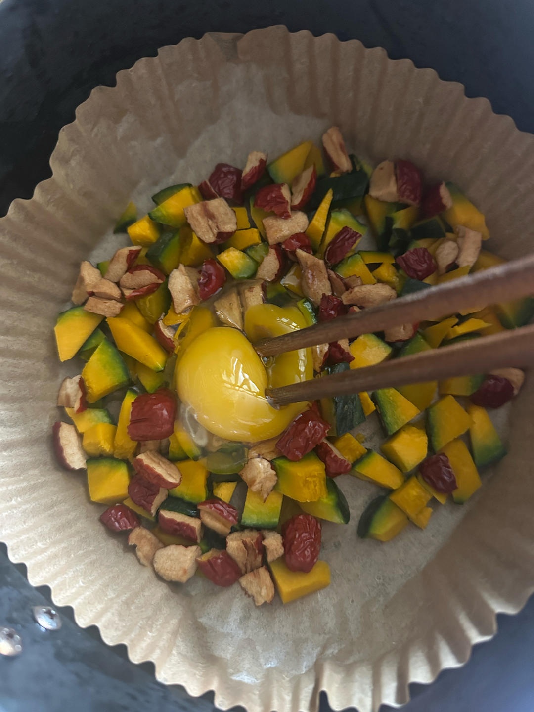 Egg being stirred into the diced kabocha and red dates
