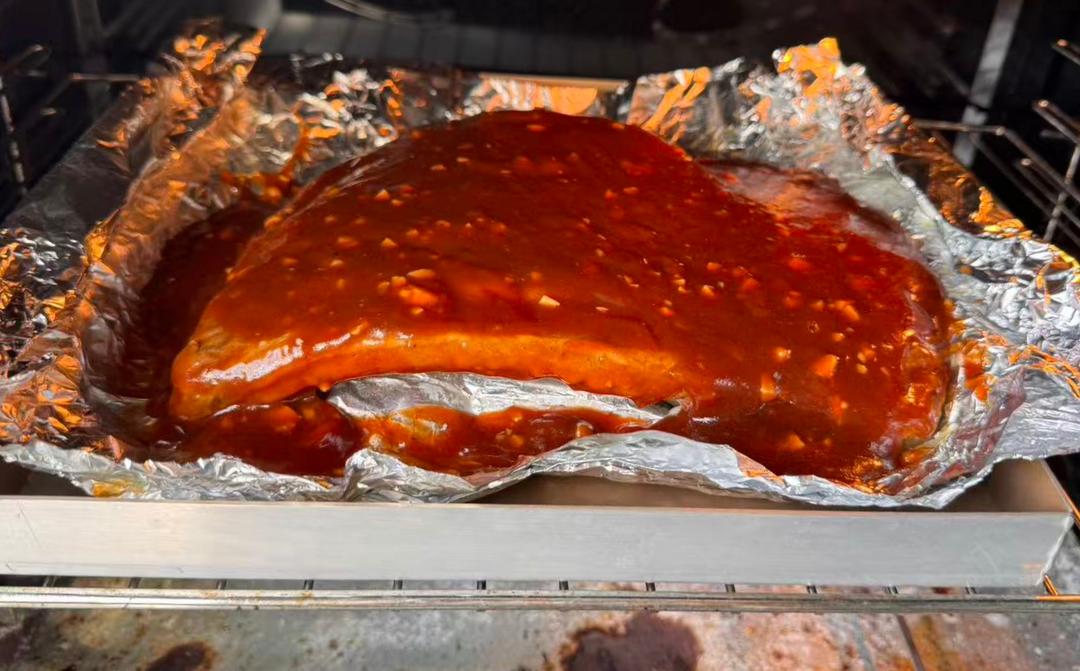 Glazing the ribs with barbecue sauce at high heat
