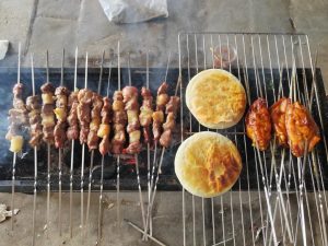 Lamb skewers and chicken wings on the grill