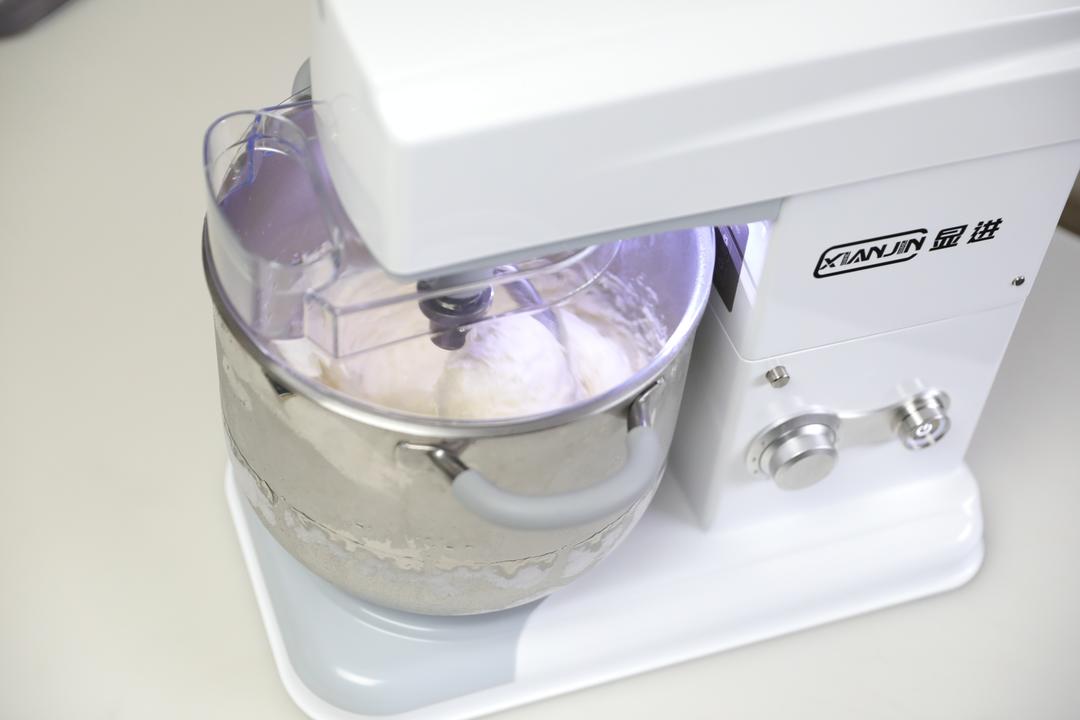 Sticky dough kneading in the mixer being checked for temperature