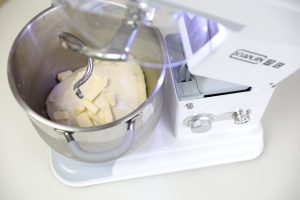 Adding softened butter to the dough in the mixer
