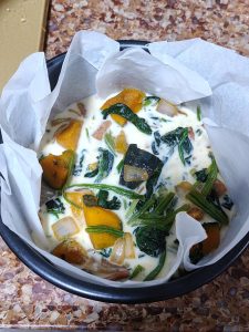 Prepare the custard by whisking the milk with the flour and eggs, then season with a little salt and black pepper. Line a mold with parchment paper, pour in half of the filling and