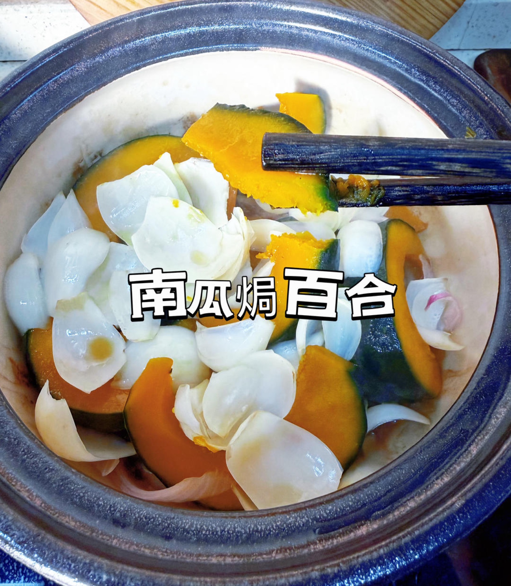 Baked pumpkin with lily bulbs in a clay pot, garnished with scallion