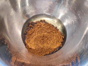 Whisking cocoa powder into corn oil to make a smooth paste
