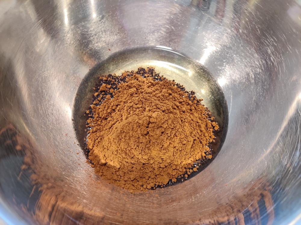 Whisking cocoa powder into corn oil to make a smooth paste