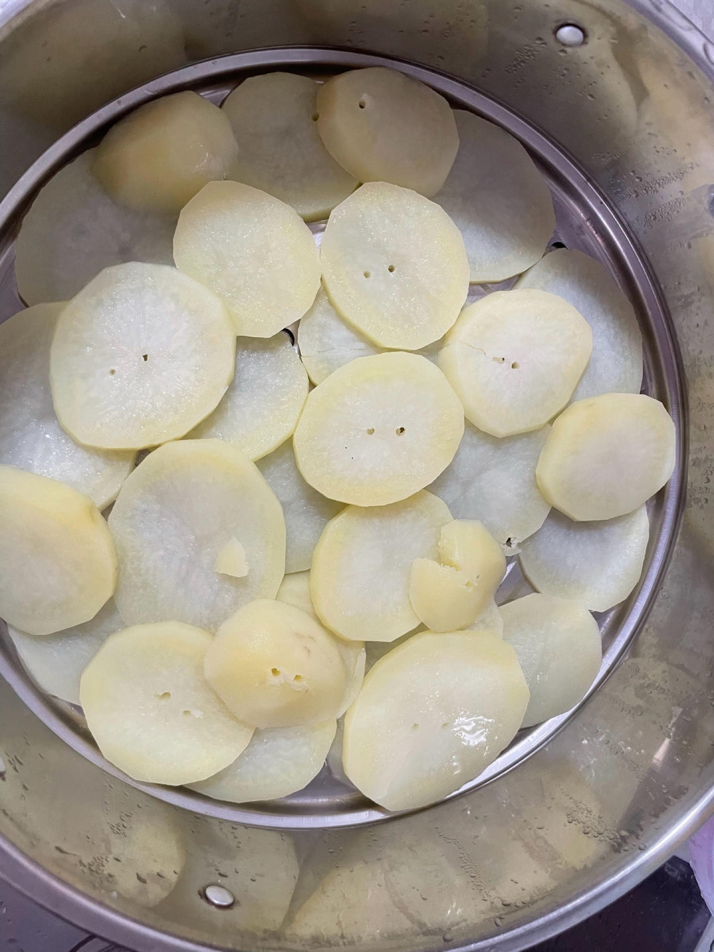 Wash, peel, and slice the potatoes, then steam them over water until completely soft and tender.