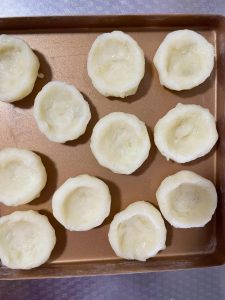 Roll the mash into balls, press each into a small bowl shape, and bake at 210°C (410°F) for 20 minutes, then remove from the oven.