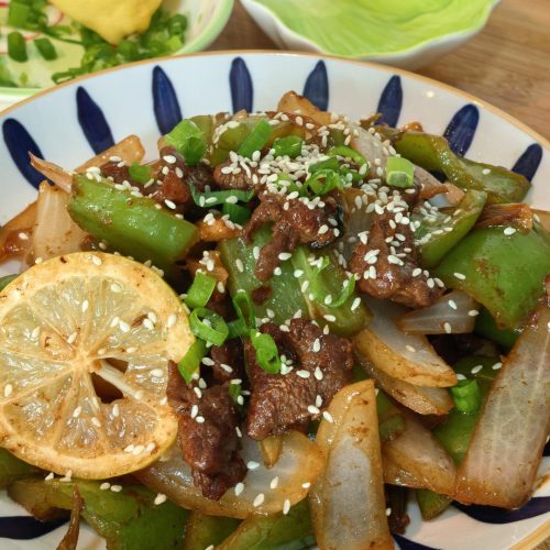Glossy beef tenderloin stir fry with green pepper and onion