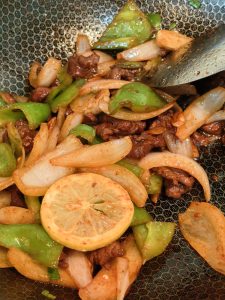 Squeezing lemon over the stir fried beef and seasoning with salt
