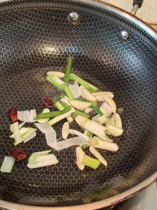 Heating the wok and frying ginger garlic and chilies