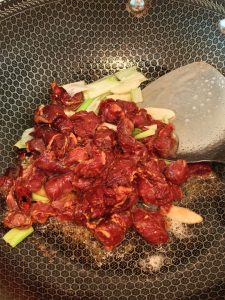Tossing the marinated beef in the hot wok