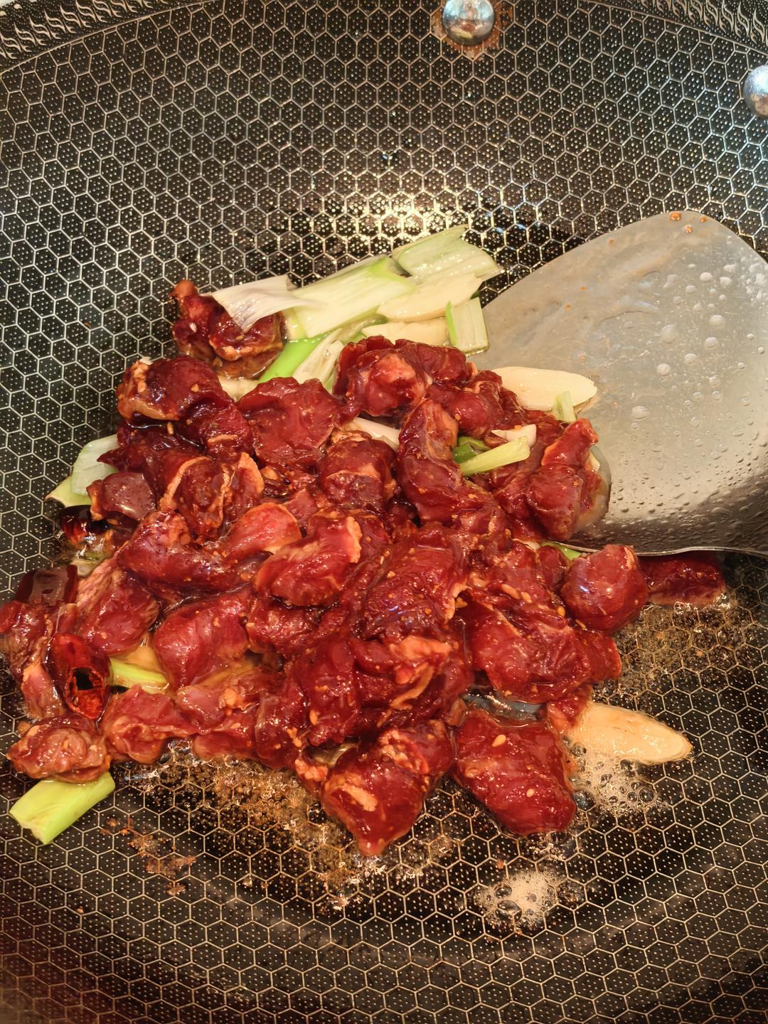 Tossing the marinated beef in the hot wok