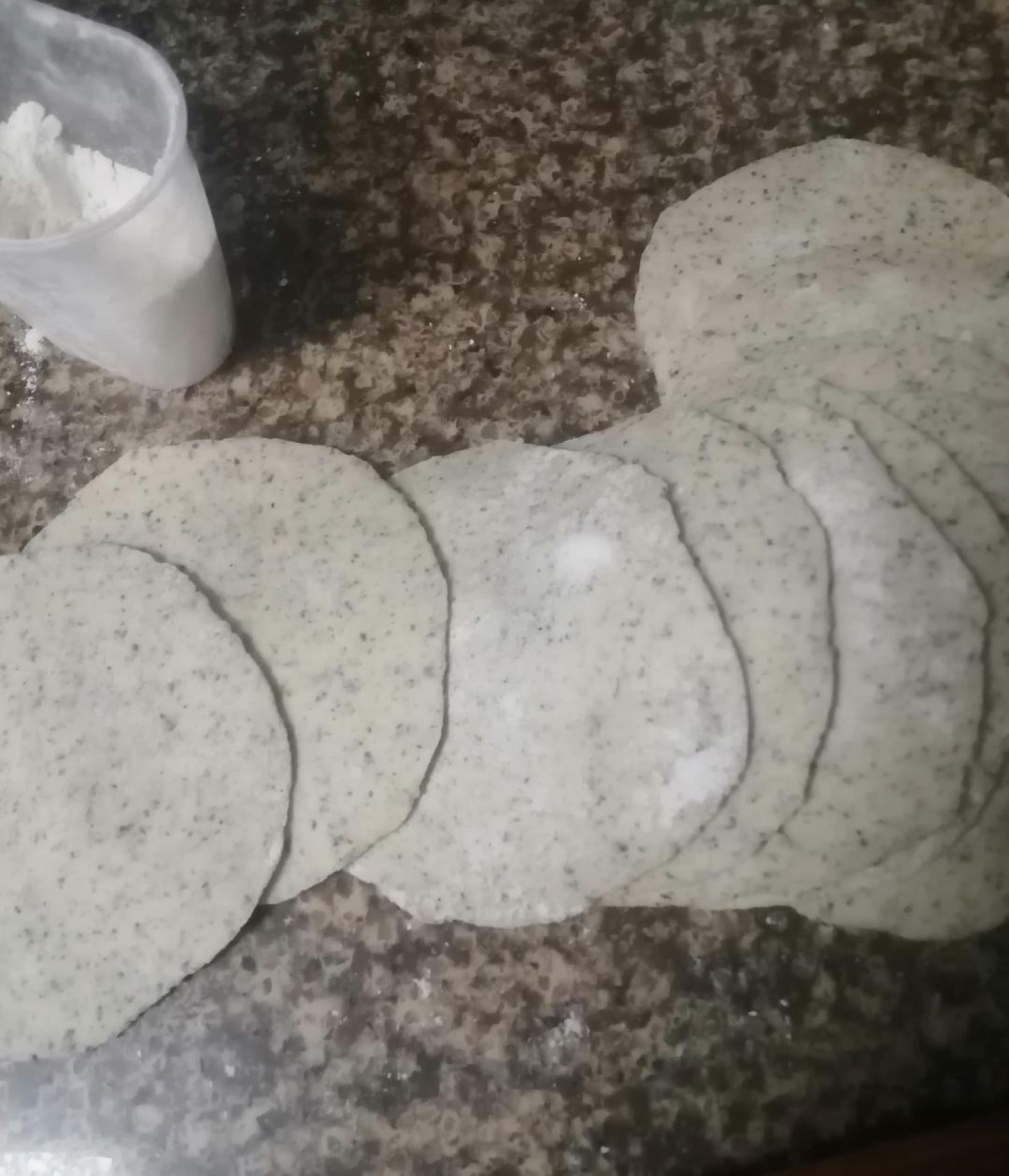 Punch the dough down, divide it into portions, and roll each portion into a round wrapper with a slightly thicker center.