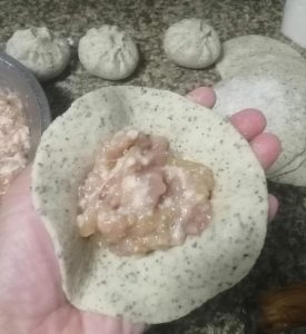 Spoon the pork filling onto each wrapper and pleat the edges closed, pinching firmly to seal.