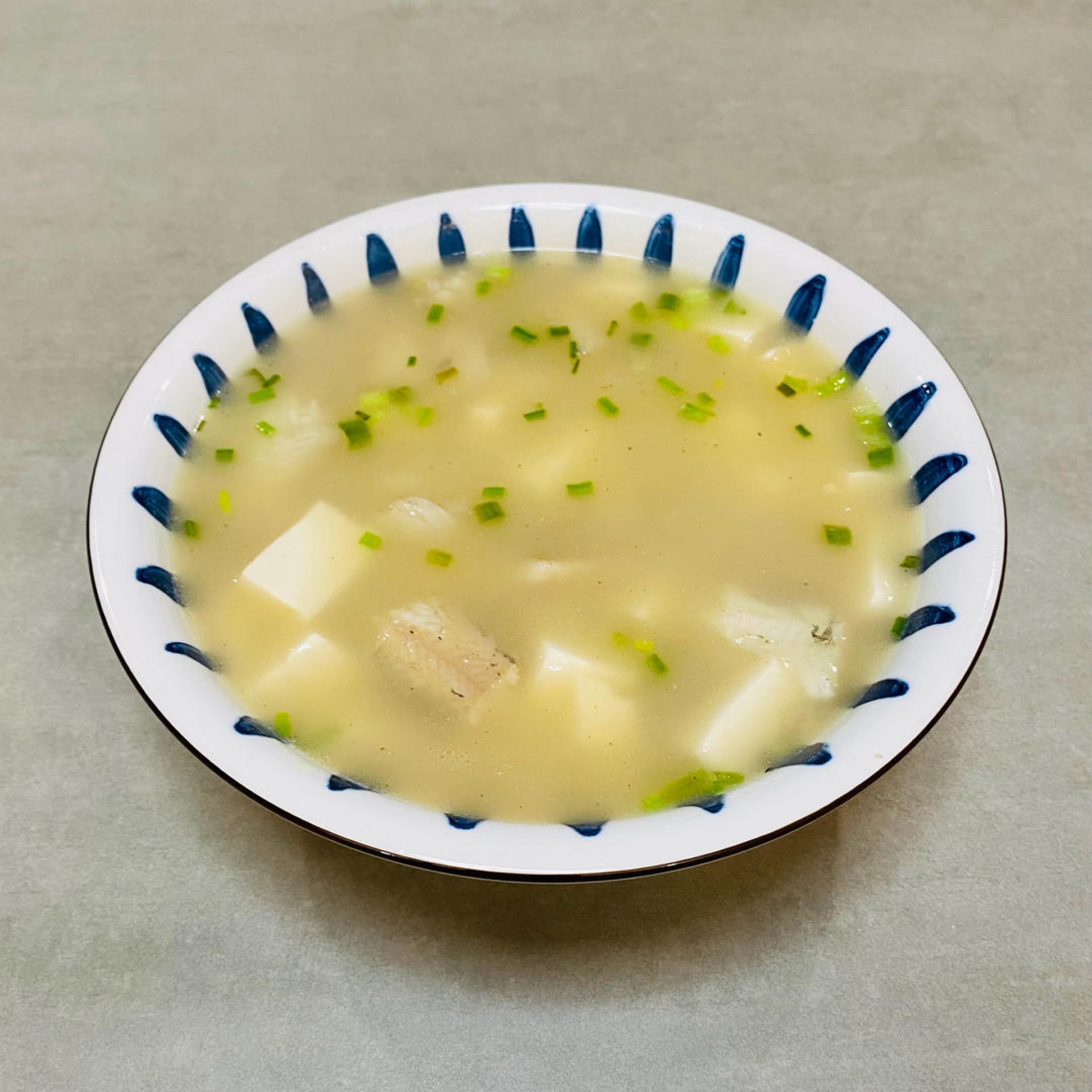 Plate the soup and scatter a little more chopped scallion over the top.