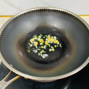 Heat a wok, melt a little lard, and stir-fry the ginger slices and scallion until fragrant.