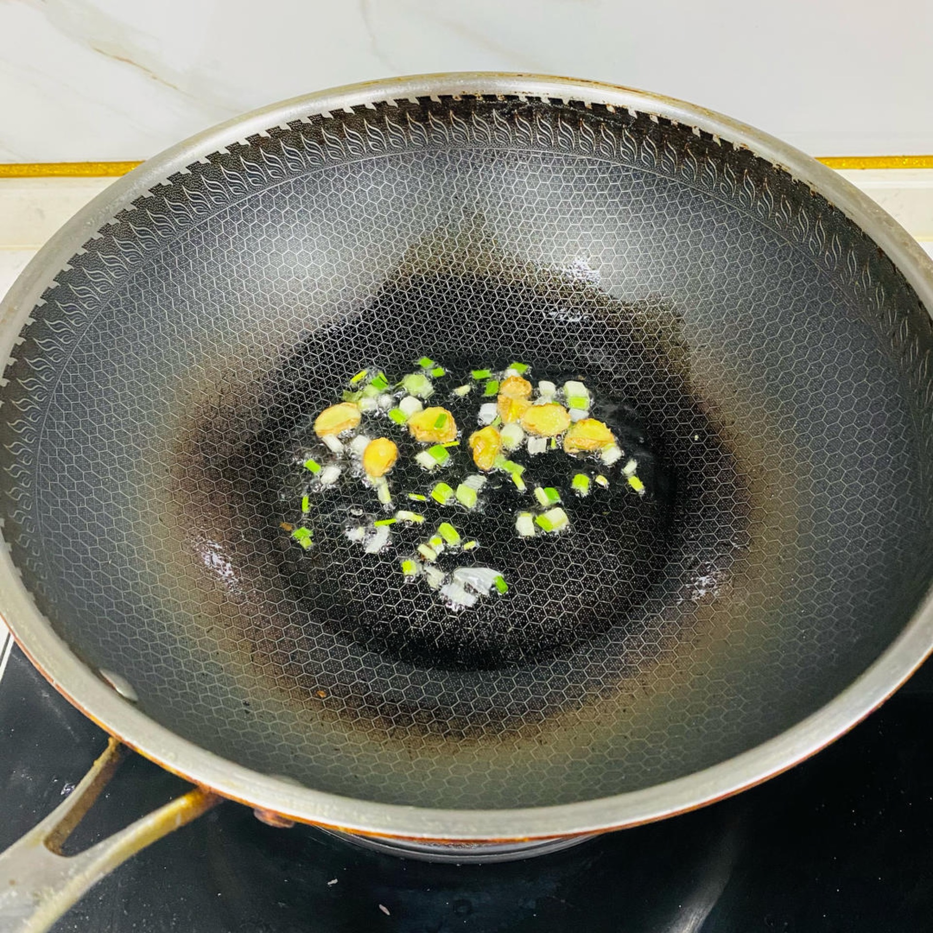 Heat a wok, melt a little lard, and stir-fry the ginger slices and scallion until fragrant.