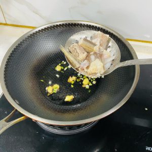 Add the blanched Bombay duck segments to the wok.