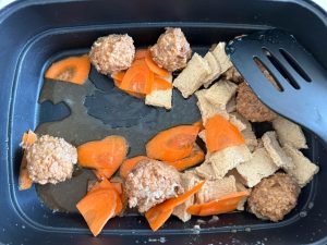 Heat the pot, add the meatballs, carrot and dried tofu, and let them warm through and pick up a little color.